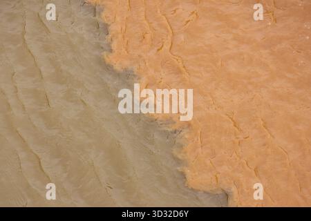 Spettacolare vista aerea della confluenza fluviale, dove si incontrano due corpi d'acqua con fango e sedimenti argillosi. il potente contrasto dei colori mostra un flusso di miscelazione di n Foto Stock