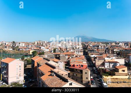 Una vista panoramica di Catania si estende sotto il limpido cielo siciliano, con l'Etna alto sullo sfondo. L'immagine cattura il warmt della città Foto Stock