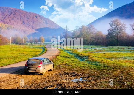 perechyn, ucraina - 10 novembre 2020: auto vicino alla strada asfaltata in autunno. viaggio attraverso il paesaggio di campagna montano dell'ucraina con la nebbia mattutina. cappello hyundai Foto Stock