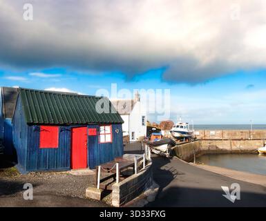 capanna o capanna in legno colorata e vintage sul molo presso il porto di st abbs, scottish borders, scozia Foto Stock