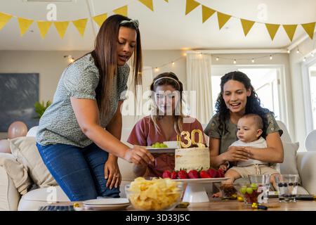 Festeggiamo il compleanno, amici diversi che si godono torte e spuntini durante la riunione di casa. Celebrazione, amicizia, festa, dessert, socializzazione, cameratismo || modello rilasciato Foto Stock