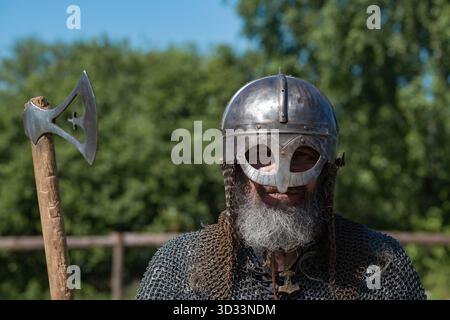 SHEVELEVO, RUSSIA - 18 LUGLIO 2025: Ritratto di un vichingo anziano che indossa un casco. Ricostruzione storica Foto Stock
