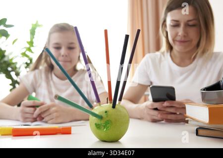 Madre e figlia che si divertono durante il lavoro per la scuola a casa Foto Stock