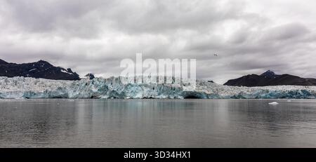 Ghiacciaio di Wahlenberg alle Svalbard. Oceano, ghiaccio e montagne con cielo nuvoloso Foto Stock