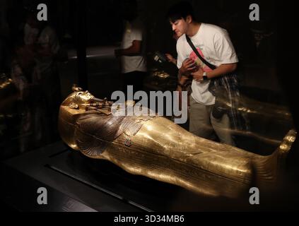 Cairo, Egitto. 4 novembre 2025. Il 4 novembre 2025 i turisti potranno ammirare una bara dorata presso la sala esposizioni King Tutankhamon del Grand Egyptian Museum di Giza, Egitto. Il Grand Egyptian Museum (GEM), il più grande museo del mondo dedicato a una singola civiltà, è stato aperto al pubblico il martedì. Crediti: Sui Xiankai/Xinhua/Alamy Live News Foto Stock