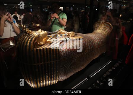 Cairo, Egitto. 4 novembre 2025. Il 4 novembre 2025 i turisti potranno ammirare una bara dorata presso la sala esposizioni King Tutankhamon del Grand Egyptian Museum di Giza, Egitto. Il Grand Egyptian Museum (GEM), il più grande museo del mondo dedicato a una singola civiltà, è stato aperto al pubblico il martedì. Crediti: Sui Xiankai/Xinhua/Alamy Live News Foto Stock