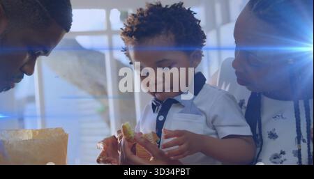 Bambino che esamina la fodera del muffin strappata, le metà del muffin nell'angolo colazione, con sacchetto di carta sgualcito Foto Stock
