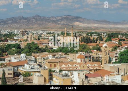 Ampia vista su Nicosia verso la Moschea Selimiye e i Monti Kyrenia sotto un cielo estivo. Foto Stock
