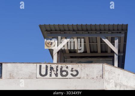 Nicosia, Cipro Vista ravvicinata di un posto di osservazione delle Nazioni Unite per il mantenimento della pace contrassegnato con “UN65” con emblema sotto un cielo azzurro limpido. Foto Stock