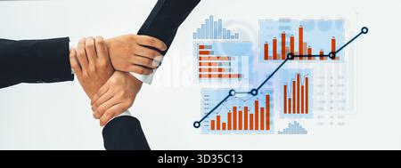 Questa immagine mostra il lavoro di squadra con le mani che si uniscono su grafici e grafici, simboleggiando la collaborazione nella crescita aziendale e il successo basato sui dati Foto Stock