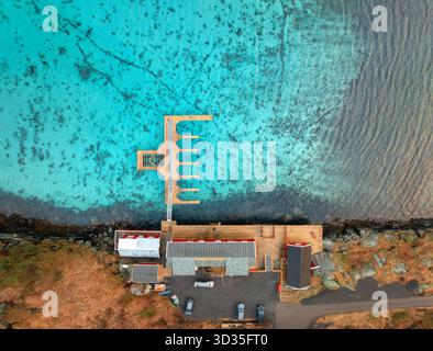 Vista aerea del molo in legno, acqua azzurra, case sulla costa del mare Foto Stock