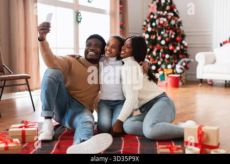 La famiglia Happy Black celebra il Natale con un gioioso selfie a casa Foto Stock
