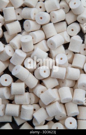 Vista completa dall'alto verso il basso di molti piccoli cilindri di lucidatura e lucidatura in feltro bianco. Foto Stock