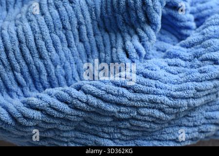 Foto macro di morbida coperta a maglia blu, confortevole sfondo in tessuto. Foto Stock