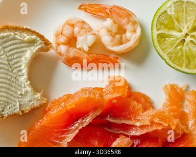Vista dall'alto su salmone, gamberi e calce a fette Foto Stock