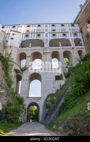 Il ponte Cloak è un ponte a più archi su un fossato del castello, con vista sul castello e sulla città vecchia di Cesky Krumlov. Foto Stock