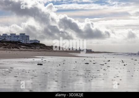 Spiaggia sabbiosa sulla costa atlantica. Vista dello skyline di Rota, cielo nuvoloso sulla spiaggia Playa de la Costilla, Costa de la Luz, Cádiz, Andalusia, Spagna. Foto Stock