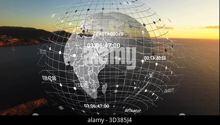 Visualizzazione del globo a reticolo digitale con linee della griglia e etichette numeriche sul paesaggio marino costiero al tramonto Foto Stock