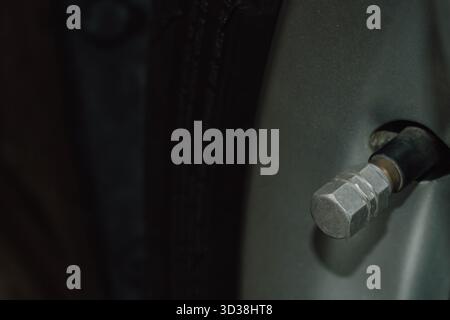Primo piano del nipplo dello stelo della valvola di uno pneumatico per auto utilizzato per il gonfiaggio della pressione dell'aria Foto Stock