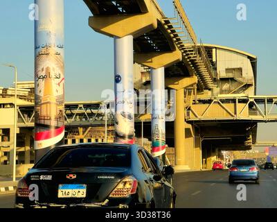 Cairo, Egitto, ottobre 28 2025: Ponte ferroviario El Ferdan, treno elettrico veloce e stazione ferroviaria di Bashteel sulle colonne della nuova monorotaia del Cairo Foto Stock