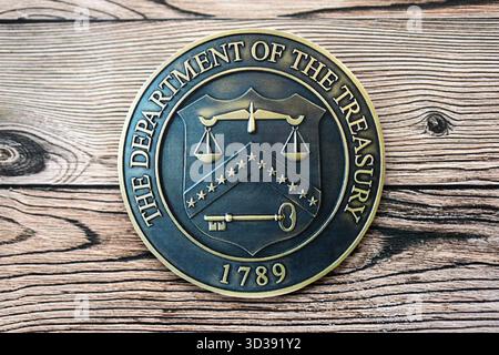 KYIV, UKRAINE - OCTOBER 7, 2025 US Department Of The Treasury emblem on wooden table surface close up Foto Stock