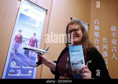 Londra, Gran Bretagna. 4 novembre 2025. Un membro dello staff posa per le foto con un modello di aereo al padiglione Cina del World Travel Market (WTM) London 2025 a Londra, Gran Bretagna, 4 novembre 2025. Il WTM London 2025 è stato inaugurato martedì, con il padiglione della Cina che attira l'attenzione per le sue abbondanti risorse turistiche e il suo fascino culturale. Crediti: Li Ying/Xinhua/Alamy Live News Foto Stock