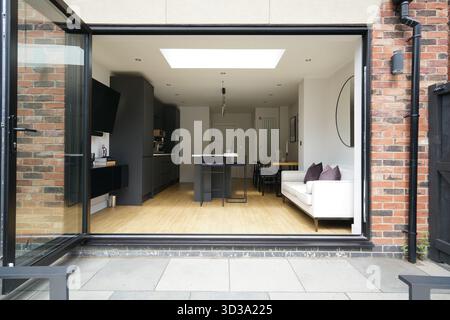 Moderna cucina open space e zona soggiorno con luce naturale in un'elegante casa urbana Foto Stock