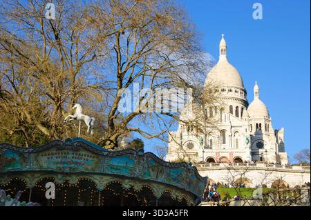 Vista della Basilica del Sacro cuore e di un'antica giostra in primo piano. Parigi, Francia. Foto Stock