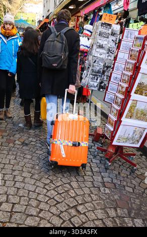 PARIGI, FRANCIA - 29 DICEMBRE 2013: Turisti che camminano vicino alle gallerie d'arte e ai negozi di souvenir di Montmartre, vicino alla famosa Basilica del Sacro cuore. Foto Stock