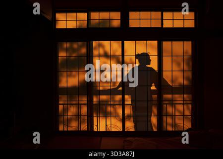 Ombre di una donna in kimono, sul balcone dietro porte scorrevoli shoji in una casa tradizionale giapponese, Yamanouchi, Nagano, Giappone Foto Stock