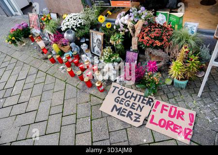 Oldenburg, Germania. 5 novembre 2025. Due cartelli con la scritta "Töchter gegen Merz" ("Figlie contro Merz") e "für Lorenz" ("per Lorenz"), oltre a numerosi fiori, candele e foto, si trovano sulla scena del crimine nel centro della città in memoria di Lorenz, ferito a morte da un colpo di pistola della polizia. Dopo la sparatoria fatale del ventunenne, l'ufficio del pubblico ministero ha accusato un agente di polizia per omicidio colposo. Crediti: Hauke-Christian Dittrich/dpa/Alamy Live News Foto Stock
