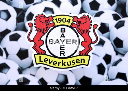 KIEV, UCRAINA - 23 FEBBRAIO 2025 il distintivo della squadra di calcio Bayer 04 Leverkusen si trova sullo sfondo delle palle da calcio Foto Stock