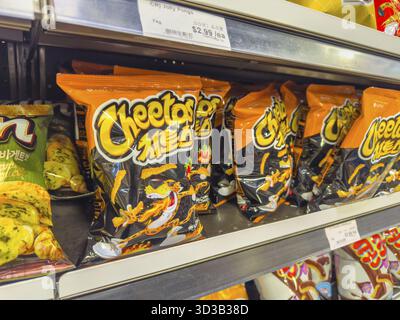 Calgary, Alberta, Canada. 10 aprile 2025. Uno scaffale con sacchetti da 178 g di spuntini coreani lotte Cheetos Sweet Spicy Foto Stock