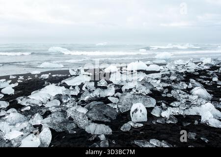Diamond Beach in Islanda, dove gli iceberg della laguna del ghiacciaio Jokulsarlon si lavano a riva, creando una scena surreale di scintillanti ghiacci vulcanici sparsi Foto Stock
