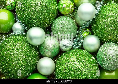 Sfondo natalizio con baule e ornamenti di colore verde chiaro. Primo piano di palle di Natale verde chiaro, varie dimensioni, sfumature e texture. Fil Foto Stock