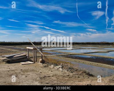 Guerande, Francia - 01 ottobre 2025: Saline tradizionali a Les Marais Salants de Guerande, Francia, sotto un cielo luminoso di mezzogiorno, con laghetti di evaporazione e attrezzi pronti per la raccolta. Foto Stock