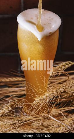 Cibo, versare birra nel bicchiere con le orecchie di grano Foto Stock
