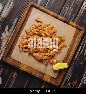 Cibo, piccoli gamberi cotti su vassoio di legno Foto Stock