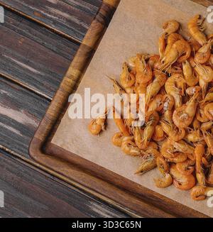 Cibo, piccoli gamberi cotti su vassoio di legno Foto Stock