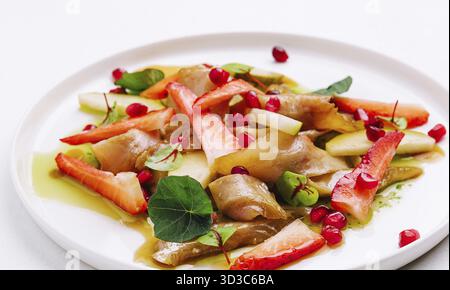 Cibo, pesce con fragole, pere e melograni in salsa Foto Stock
