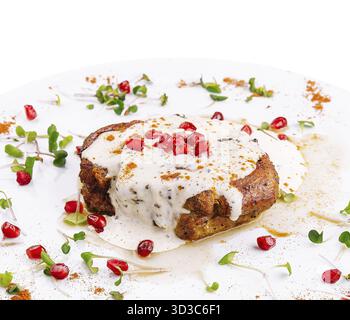 Cibo, deliziosa costoletta di maiale stufata in una cremosa salsa di vino con erbe aromatiche Foto Stock