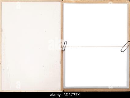 Pagine di un libro vintage con cornici fotografiche vuote attaccate con graffette. Foto Stock