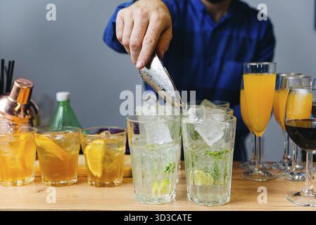 Cibo, barman che prepara cocktail al bancone del bar, primo piano. Barista che prepara bevande alcoliche Foto Stock