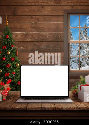 Accogliente composizione natalizia verticale con laptop sul tavolo, albero decorato, regali e vista sulla foresta innevata attraverso una finestra in legno Foto Stock