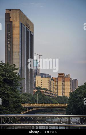 Chengdu, Cina - luglio 2019: Hotel commerciale con grattacieli e ponti sul fiume Jin nella città di Chengdu, provincia di Sichuan Foto Stock