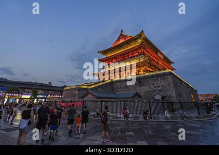 Xian, Cina - luglio 2019 : turisti che camminano di fronte alla Torre del tamburo Campanile splendidamente illuminata e illuminata di notte, provincia di Shaaxi, Cina centrale Foto Stock