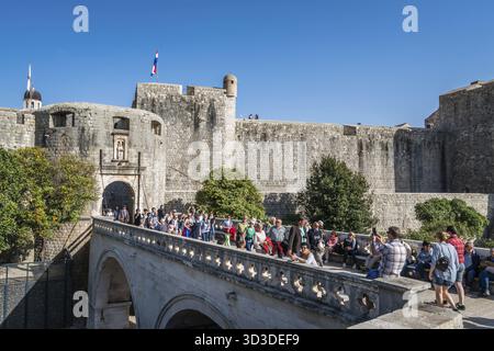 Dubrovnik, Croatia - April 2018 : Crowd of people crossing the moat bridge leading to the massive thick stone gates to the historic Old Town in Dubrov Foto Stock