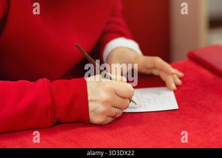 Donna che scrive in calligrafia con penna stilografica in primo piano Foto Stock