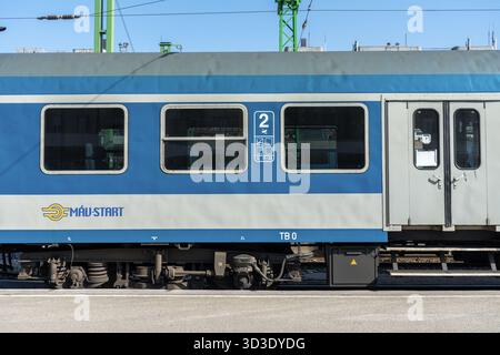 Carrozza blu delle Ferrovie statali ungheresi presso la stazione ferroviaria meridionale di Budapest con i dettagli del pullman e l'infrastruttura della piattaforma. Foto Stock