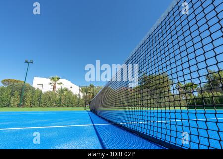 Soleggiata arena da tennis, campo aperto sotto il cielo luminoso, impianto da tennis all'aperto con tempo limpido, campo da tennis illuminato con un ambiente vivido Foto Stock